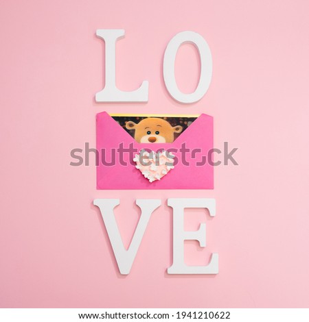 love teddy bear in a pink envelop on a pink background