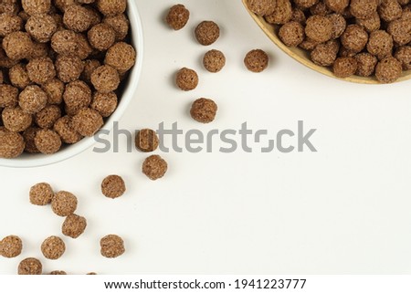 The chocolate balls are placed in a white bowl and a wooden bowl. Top view. 