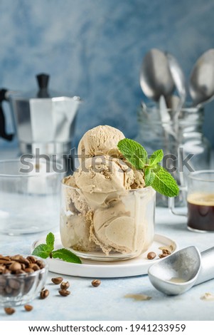 Homemade coffee ice cream in a glass on a blue background.  Coffee beans. Healthy dessert. Selective focus Royalty-Free Stock Photo #1941233959