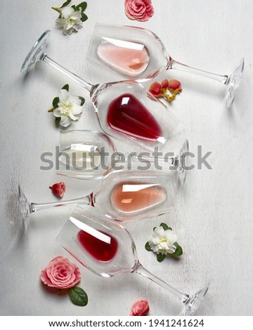 Easter wine glasses in flatlay with wite rose and red wine