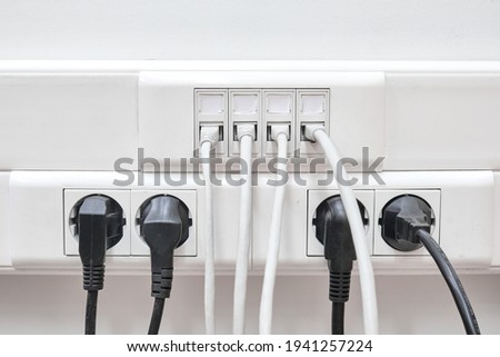 Installation of wires in electrical and local network sockets. Connecting and disconnecting computers in the office lan Royalty-Free Stock Photo #1941257224