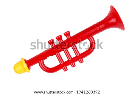 Toy trumpet of red color. Children's musical instrument. On a white background, isolated.