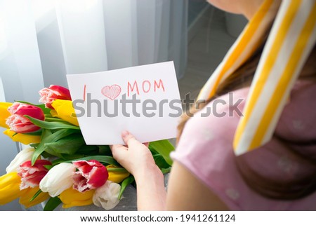 I love mom greeting card drawn by kid for Mother`s Day with beautiful bouquet of flowers in hands of woman. Preparation or make surprise to Happy Mother`s Day.