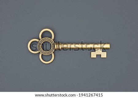 old ornate golden decorative key, vintage design element, isolated object, close-up, top view, flat lay on the black grungy background Royalty-Free Stock Photo #1941267415