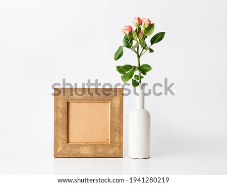 pink roses in modern white vase and frame for pictures, text, incitation, congratulation to add