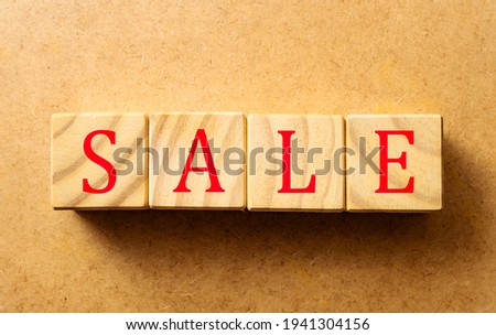 SALE word written on wooden cubes with red letters.
