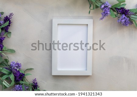 A top view of white photo frame with artificial lavender flowers