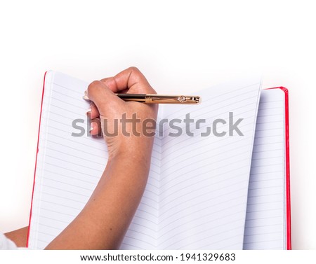 A writing hand of an Afro-American teenager girl, on the blank notepad, isolated on white background