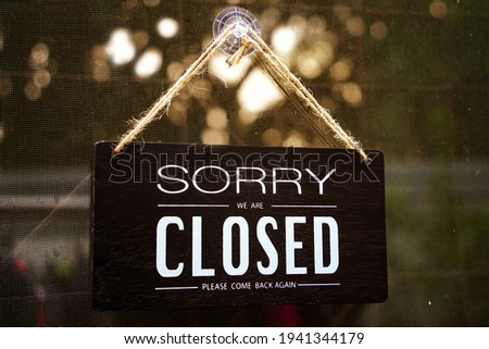sorry we're closed . black and white wood sign on white wall - process in film tone