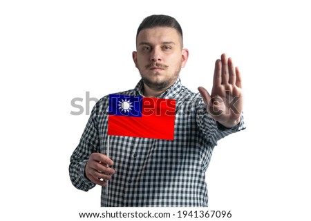 White guy holding a flag of Republic of China and with a serious face shows a hand stop sign isolated on a white background.