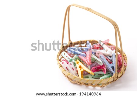 colorful clothespins that were placed in a bamboo basket