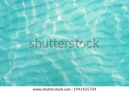 Blue sea ocean, water bright sunlight, and wave sand pattern texture natural background. Top view Royalty-Free Stock Photo #1941425704