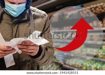 Customer surprised with high price of food during covid-19 epidemic, arrow infographics show the change in the cost of products Royalty-Free Stock Photo #1941428551