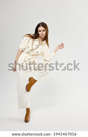 pretty woman in suit bent leg at knee fashion light background