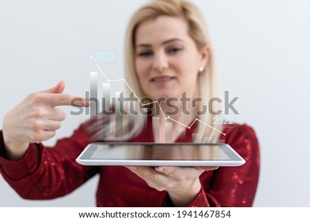 Businesswoman holding digital graphs and charts in her hands at office closeup. Successful business profit growth concept