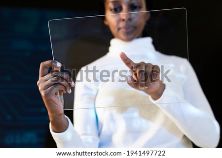 African American woman using transparent tablet futuristic technology