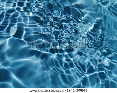Closeup​ blur​ abstract​ of​ surface​ blue​ water. Abstract​ of​ surface​ blue​ water​ reflected​ with​ sunlight​ for​ background. Blue​ sea. Blue​ water.​ Water​ splashed​ use​ for​ graphic​ design.