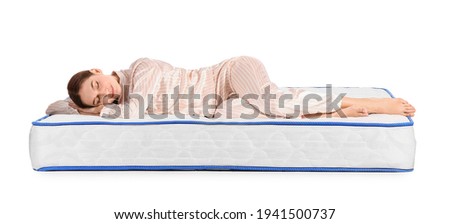 Young woman sleeping on mattress against white background Royalty-Free Stock Photo #1941500737