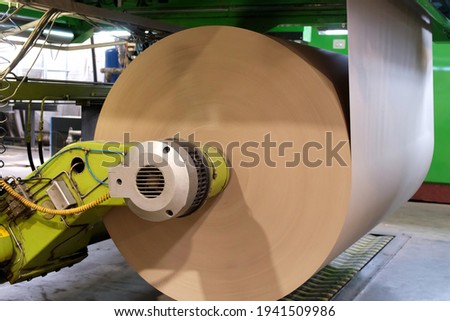 Manufacture of corrugated paper and containers of paper and paperboard. Corrugated unit for the production of 2 -, 3-and 5-layer corrugated cardboard. Corrugated packaging production line. Royalty-Free Stock Photo #1941509986
