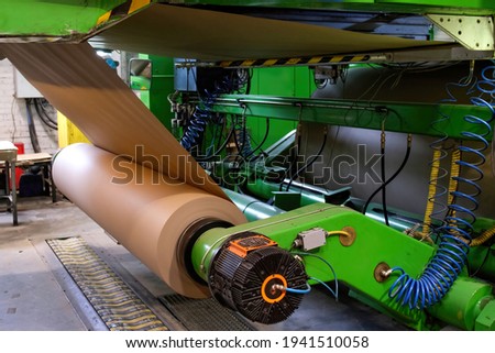 Manufacture of corrugated paper and containers of paper and paperboard. Corrugated unit for the production of 2 -, 3-and 5-layer corrugated cardboard. Corrugated packaging production line. Royalty-Free Stock Photo #1941510058
