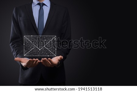 Businessman hand holding e-mail icon, Contact us by newsletter email and protect your personal information from spam mail. Customer service call center contact us concept.