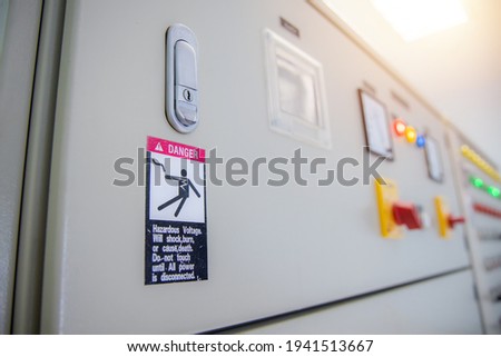 Hazardous voltage sign in main distribution board of electric plant. Warning sign on electric control cabinet of electrical room. 