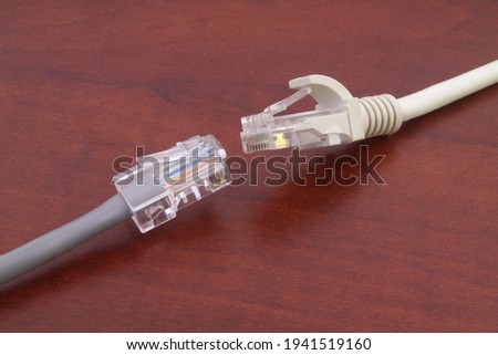 Two ethernet computer cables on wooden background. Connection, internet and computer network concept.