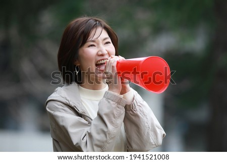 A woman holding a megaphone and cheering 