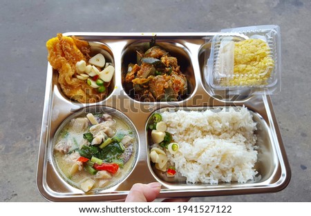 Set of Thai foods and desserts in the multiple holes tray with nutrients that the body needs in one complete meal.food for rural students,Free food ideas,thai food concept.Soft focus,Select focus  Royalty-Free Stock Photo #1941527122