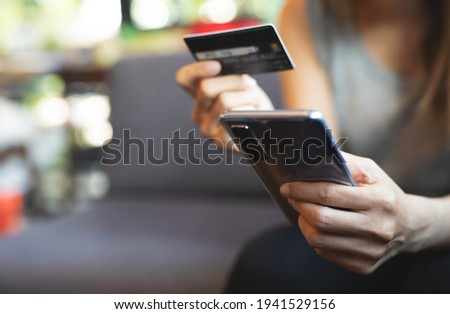 Close up image.A woman using smart phone for shopping online with credit card at coffee cafe.Online payment concept.