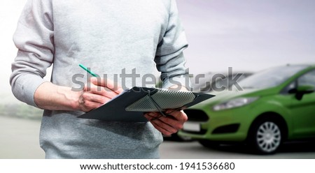 car service, repair, maintenance concept -  mechanic writing to the clipboard at workshop warehouse, technician doing the checklist for repair machine a car in the service, detailing 