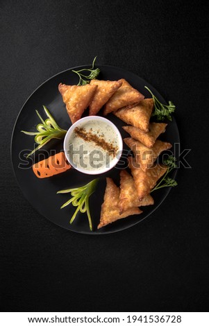 Food photography of traditional samosa with dramatic lights art direction. black background