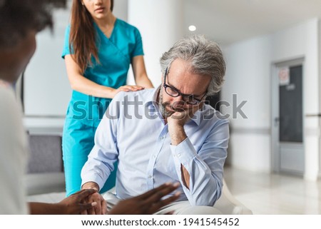 Caring young woman doctor comforting depressed unhealthy mature patient at meeting in hospital, therapist physician gp caregiver touching senior man shoulder, expressing empathy and support
