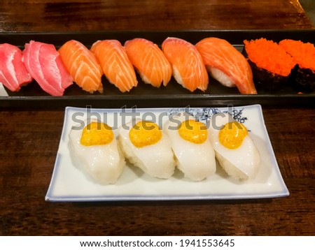 Squid Sushi, Salmon Sushi, Tuna Sushi and Shrimp Roe Sushi on plates at Japanese restaurants in Thailand.