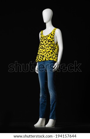 full-length female mannequin dressed in jeans on black background 
