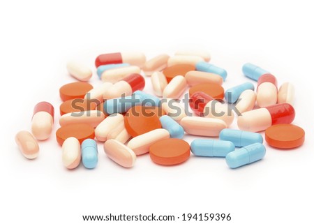 Colored pills, tablets and capsules on a white background 