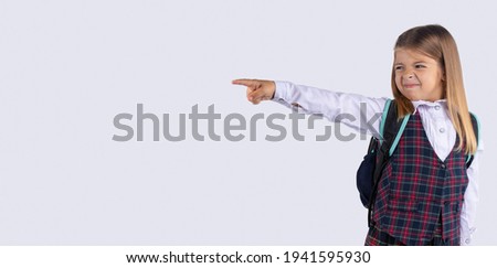 Banner, long format, grey background. Upset schoolgirl pointing her finger to side, away. Serious girl showing exit, asking to leave her alone. Get out, Get off.