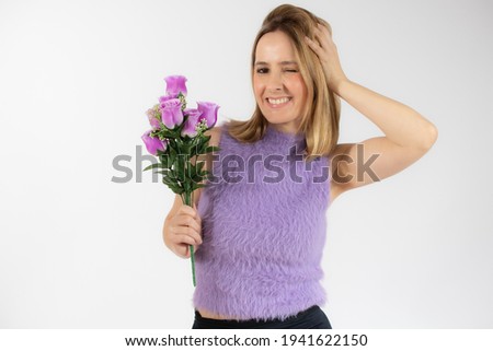 Portrait of a beautiful funny young woman in casual clothes holding bouquet of flowers isolated over white background