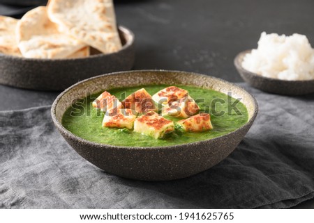 Palak Paneer served with chapati and basmati rice on grey table. Indian vegetarian cuisine made of spinach and paneer cheese. Close up. Royalty-Free Stock Photo #1941625765