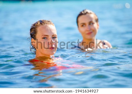 portrait of a young beautiful girls neck-deep in sea water