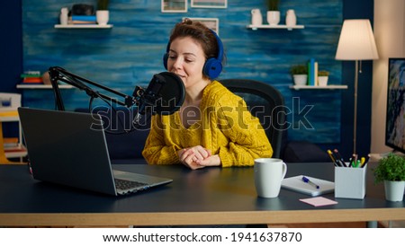 Vlogger looking at laptop and asking audience to subscribe on her channel. Online show On-air production internet broadcast host streaming live content, recording digital social media communication