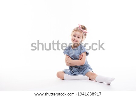 Portrait of beautiful little child model charming smile posing in the studio on a white background.