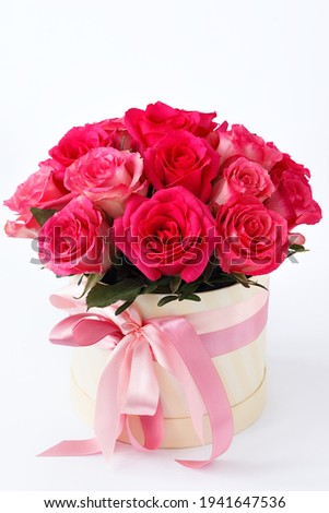 flowers in a box with ribbons on a white background, close-up with a blurred background. a bouquet of bright red roses as an anniversary gift