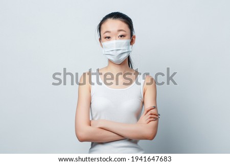 A woman wears an anti-virus mask to prevent others from contracting the coronavirus COVID-19 and SARS cov 2. Personal protective equipment against the spread of the epidemic