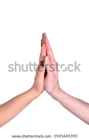 A man's hand and a woman's hand with a black manicure are pressed with palms and fingers gently and lovingly on a white isolated background