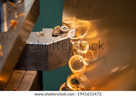 Close-up scene of lathe machine cutting the  brass material metal  parts with the cutting tools. The metalworking process by turning machine.