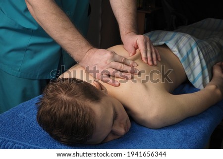 The back massage is manual. The specialist massages the back of the patient lying on the massage couch. High quality photo