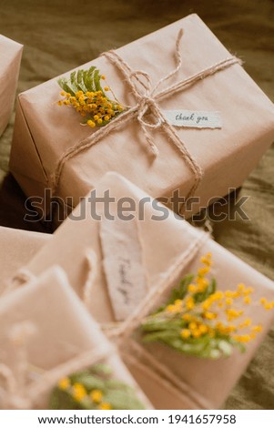 Zero waste, eco-friendly gift wrapping in kraft paper with yellow flowers and words thank you. top view. 