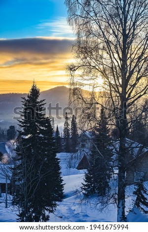 sunrise in the village on a frosty snowy morning 