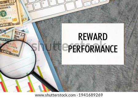 REWARD PERFORMANCE is written in a document on the office desk with office accessories, money and diagram